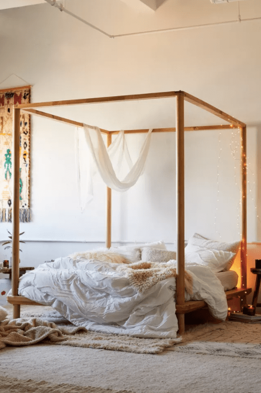 Wood Canopy Beds To Turn Your Bedroom Into A Relaxing Oasis The Mood   Cozy Bedroom With Low Wood Canopy Bed Queen Fairy Lights Urban Outfitters The Mood Guide Min 