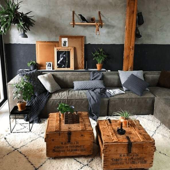 modern industrial living room with cements black walls and grey distressed leather sectional wood coffee tables
