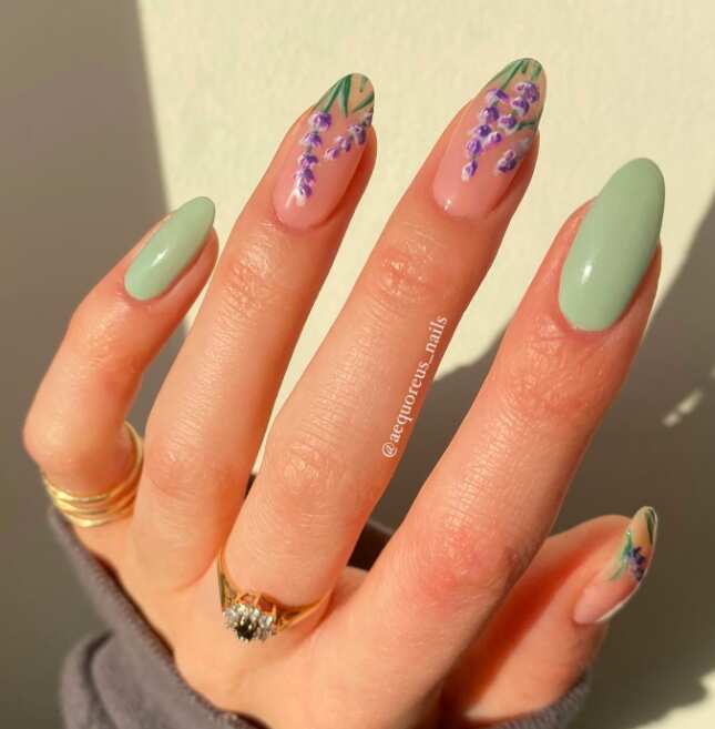 long oval nails with sage green nail polish and lavender flowers