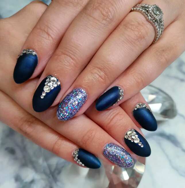 long navy blue oval nail with glitter and rhinestone