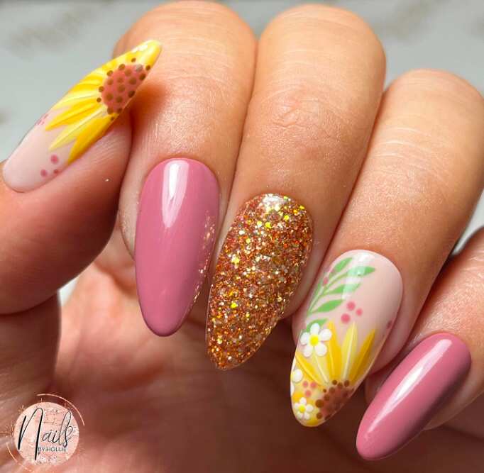 long oval nails with pink polish gold glitter and sunflower art