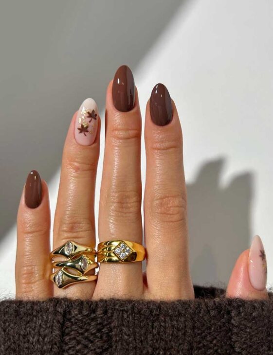 simple brown nail with minimal maple leaf design on almond nails