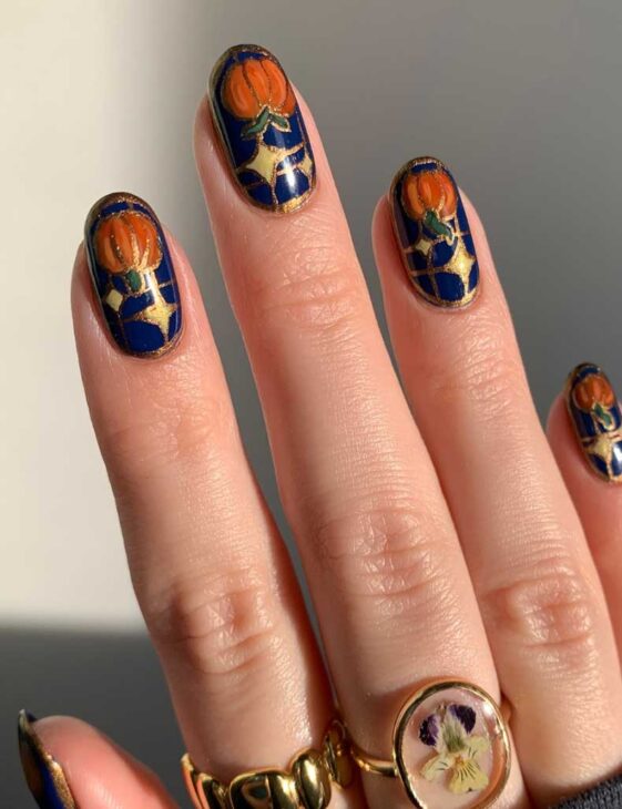 navy blue witchy aesthetic fall nails with orange pumpkin art