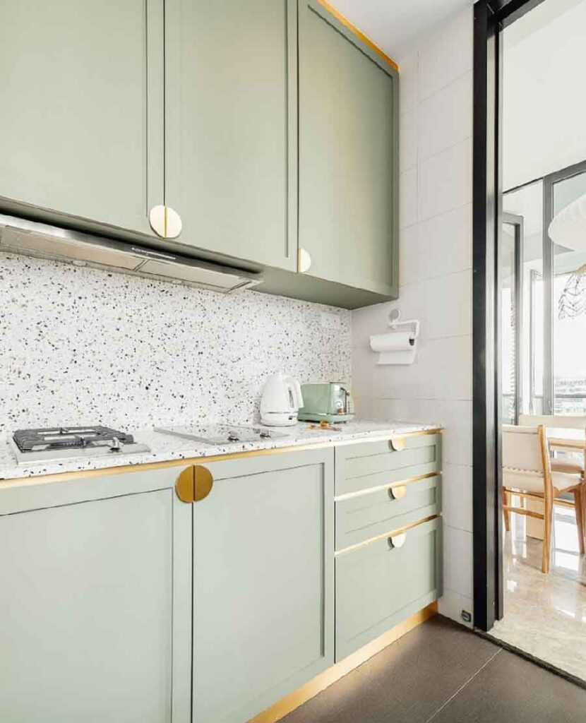 sage green kitchen cabinets with grey terrazzo countes