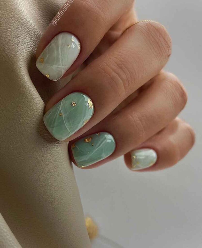 light green marble effect on short nails with gold foil flakes