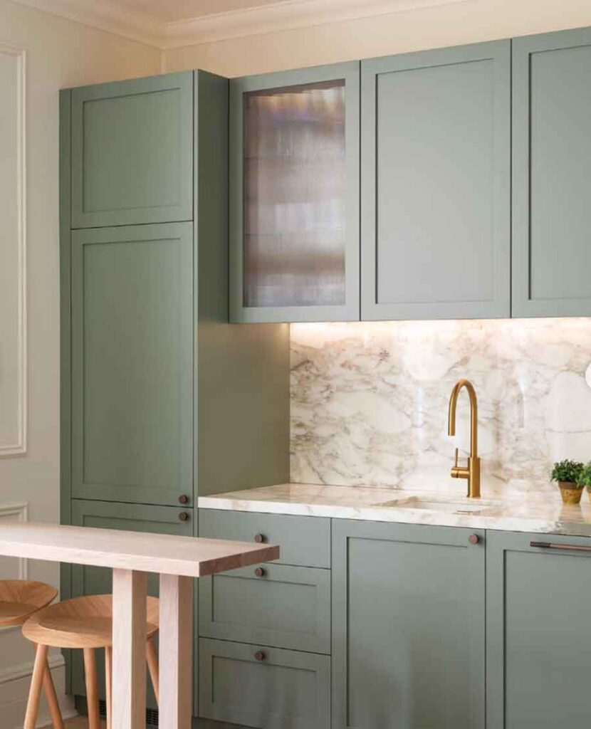 muted sage green kitchen cabinets with white marble countertop
