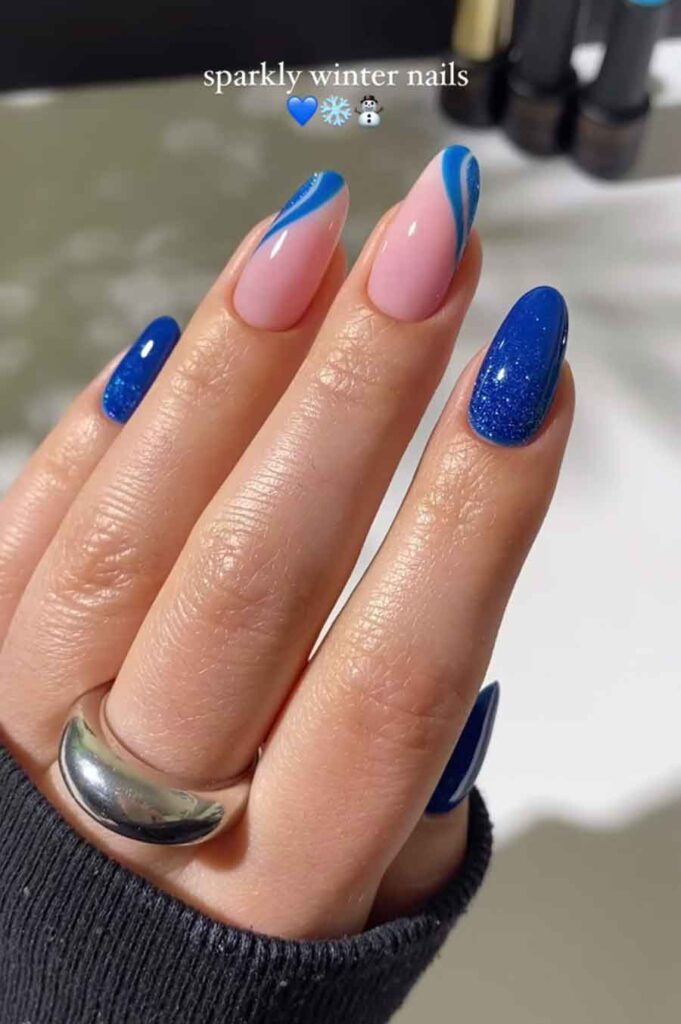 gorgeous sparkly blue nails with glitter and swirls for an elegant winter aesthetic nail art