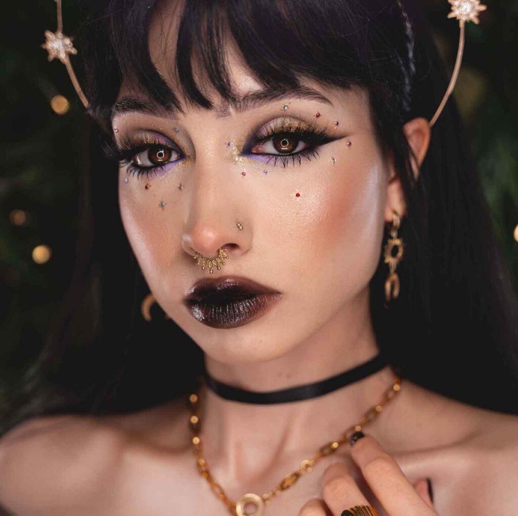 moon witch fairy aesthetic makeup with gold and purple and black eyes, gems and dark lips