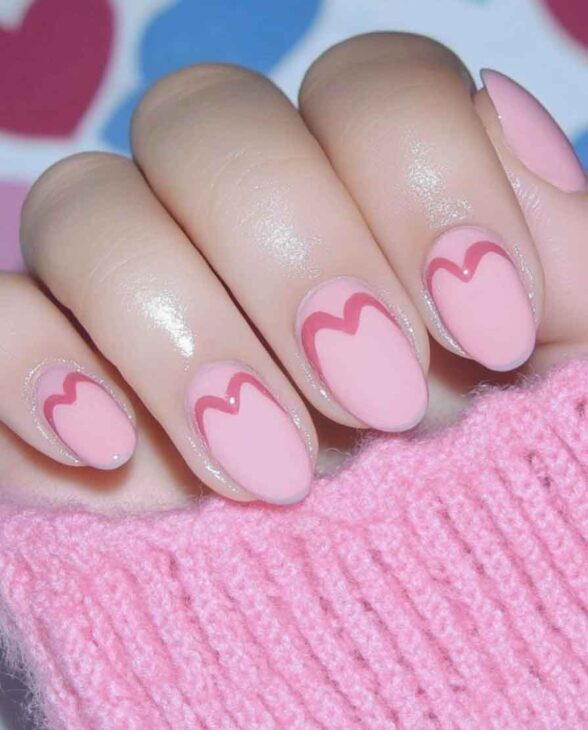 cute pink nail design on almond nails with a heart for valentines day aesthetic manicure