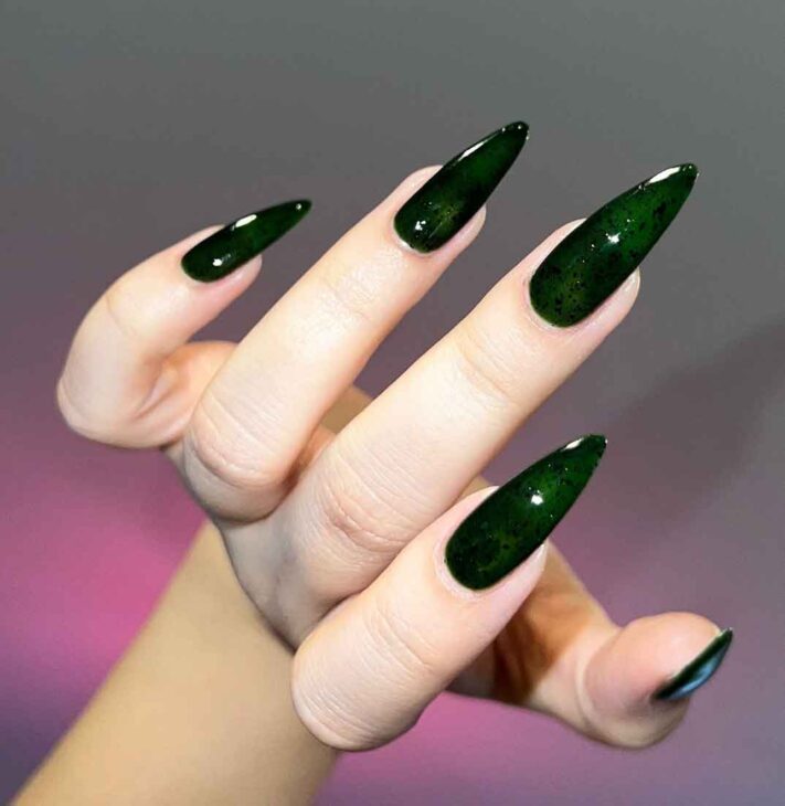 black and dark emerald green stiletto nails with a slytherin aesthetic manicure