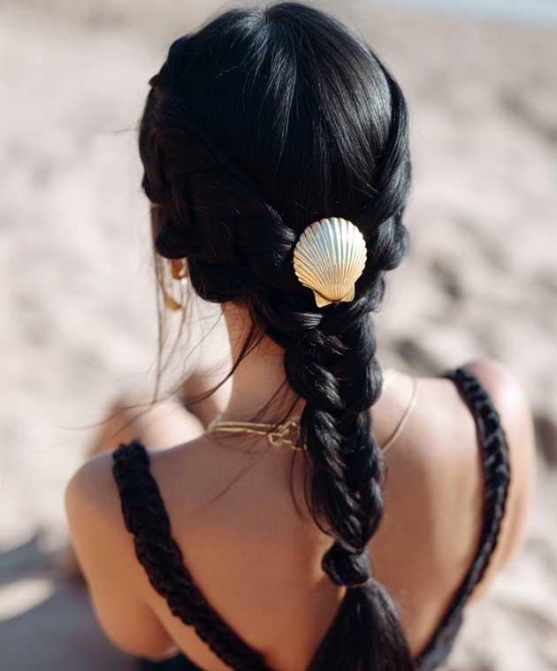 aesthetic summer hairstyle on black dark har with gold clip and braid