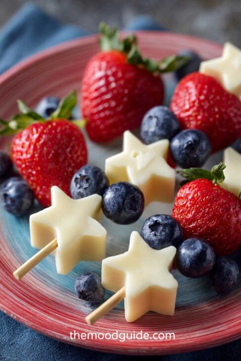 4th of july food appetizer star cut cheese cubes and fruit wands with blueberry snd strawberry