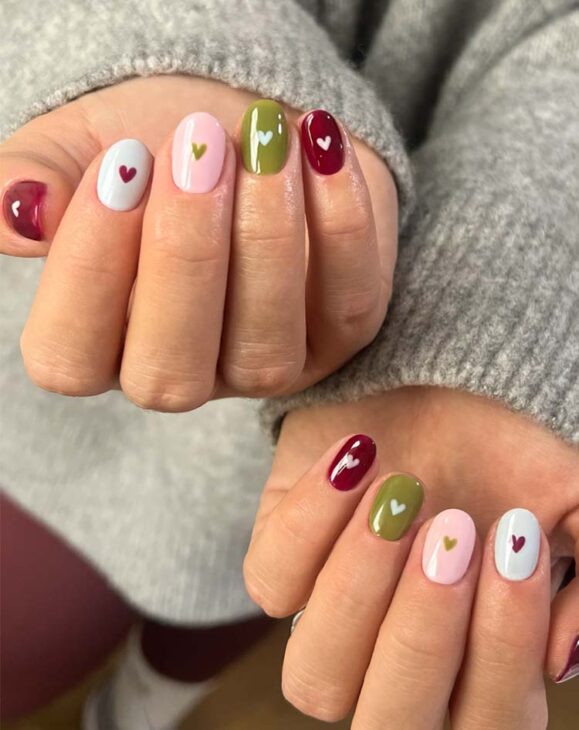 soft cute and cozy simple easy minimal aesthetic christmas nail art with olive green, burgundy and off white nail polish and heart design.