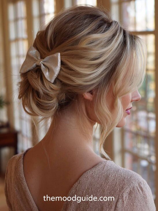 easy elegant blonde low bun all up with bow christmas eve party hairstyle on blonde hair with bangs