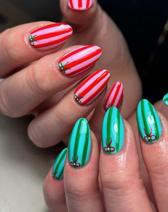 pink and red striped nails with green striped nails for Christmas with tiny bows