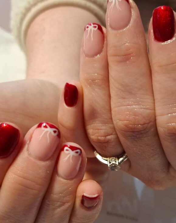 glittery red nails with white bow design on short square nails for christmas
