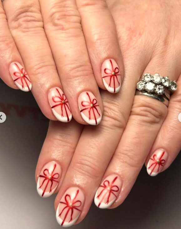 nude nails with red bow on white tips
