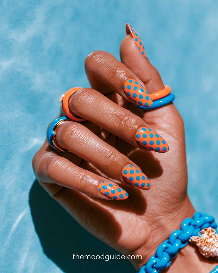 orange nails with bright blue polka dots on almond colorful summer nails